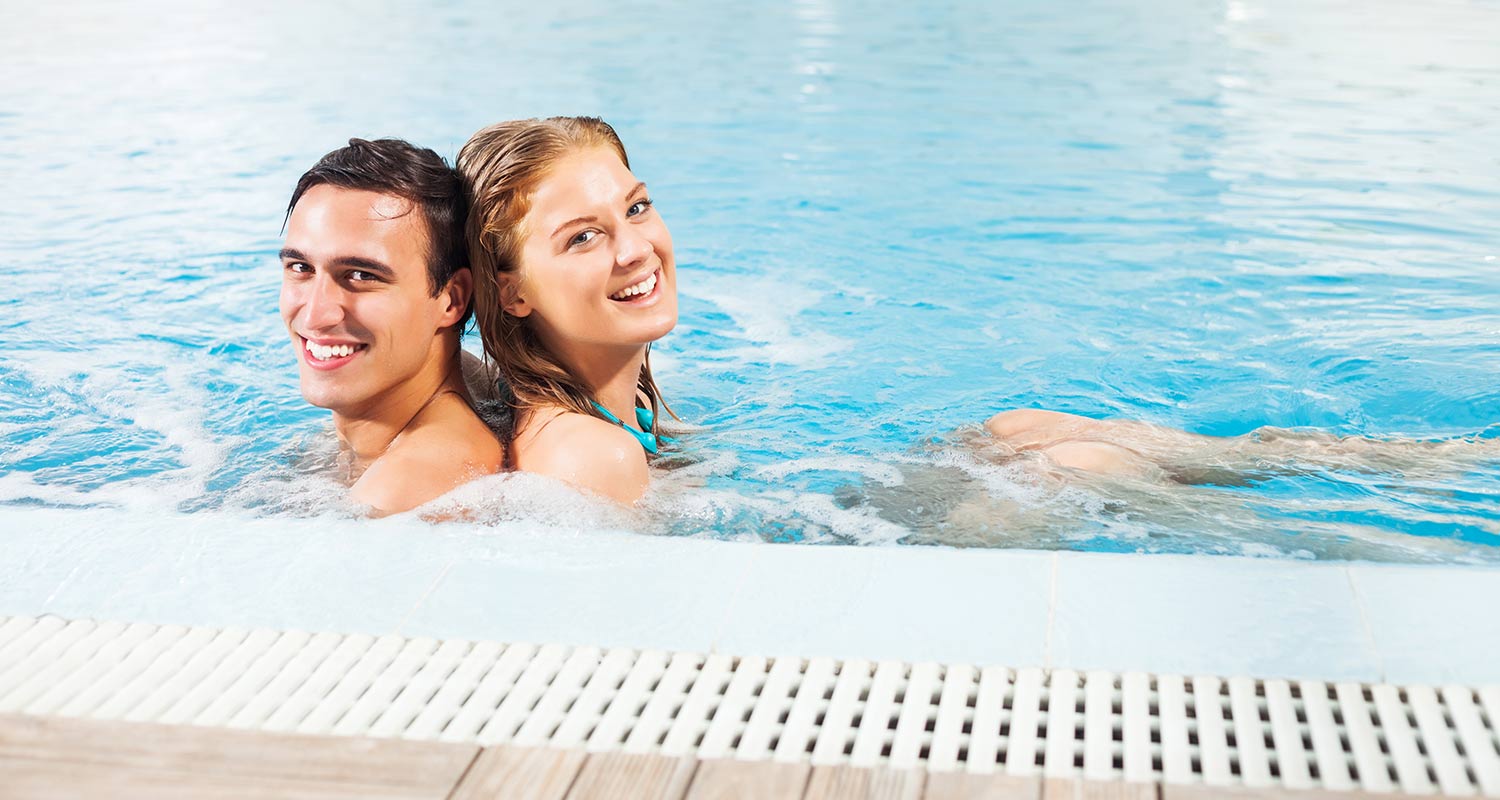 Smiling couple at indoor pool of Sporthotel Rasen