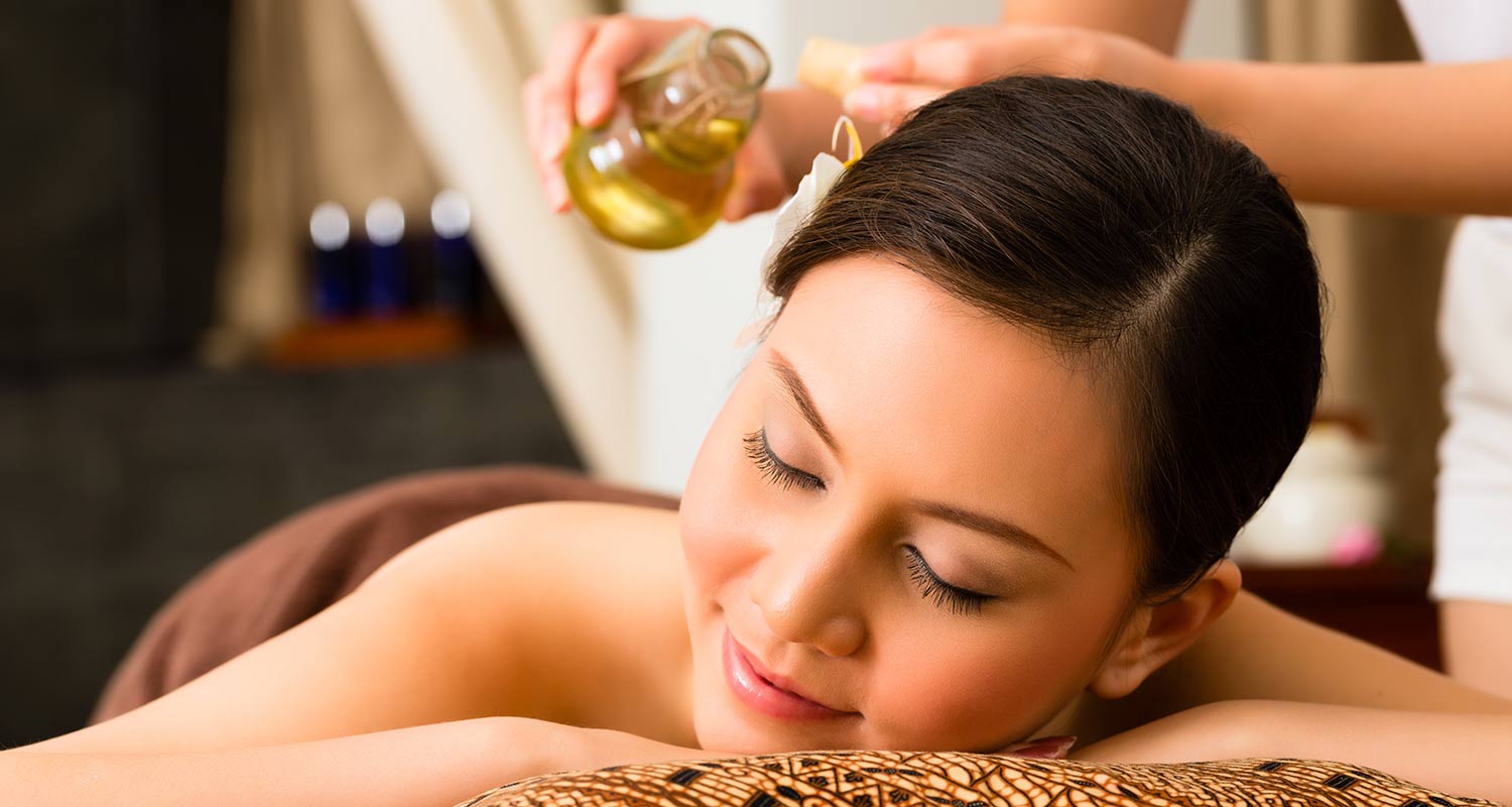 Donna con occhi chiusi durante un massaggio all'olio