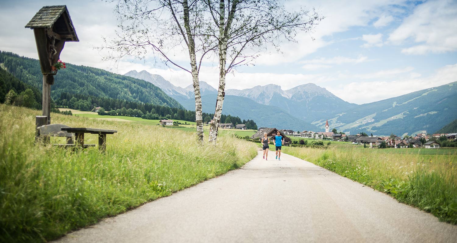 Paar wandert die Landstraße entlang Richtung Rasen Antholz