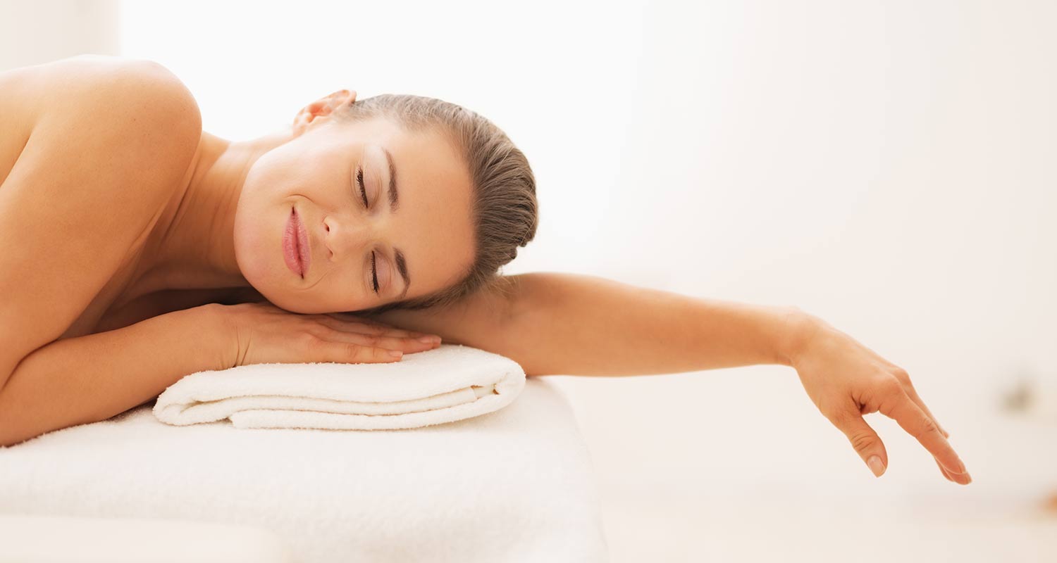 Woman lying on a towel relaxing with eyes closed