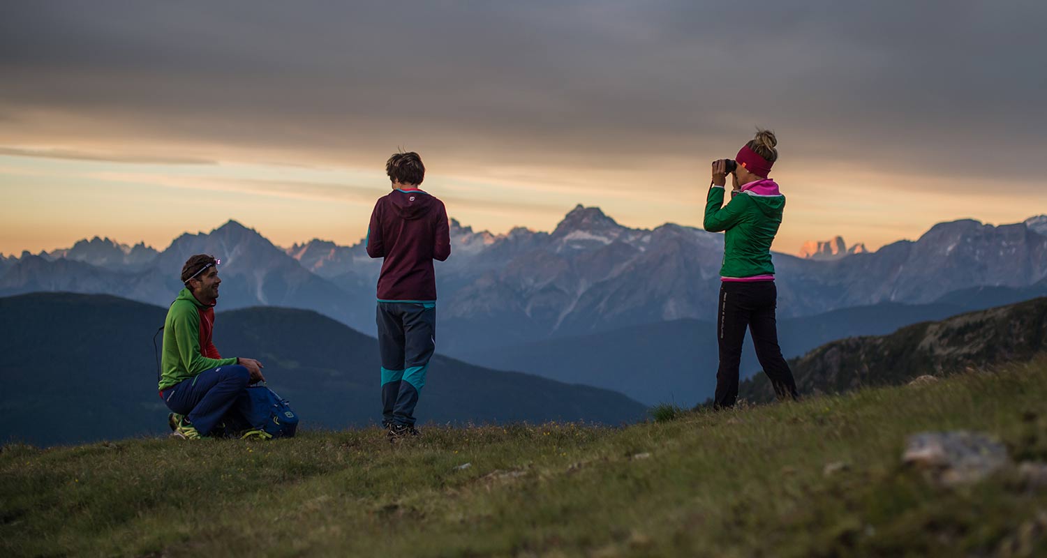 Group of young hikers on a mountain at sunset