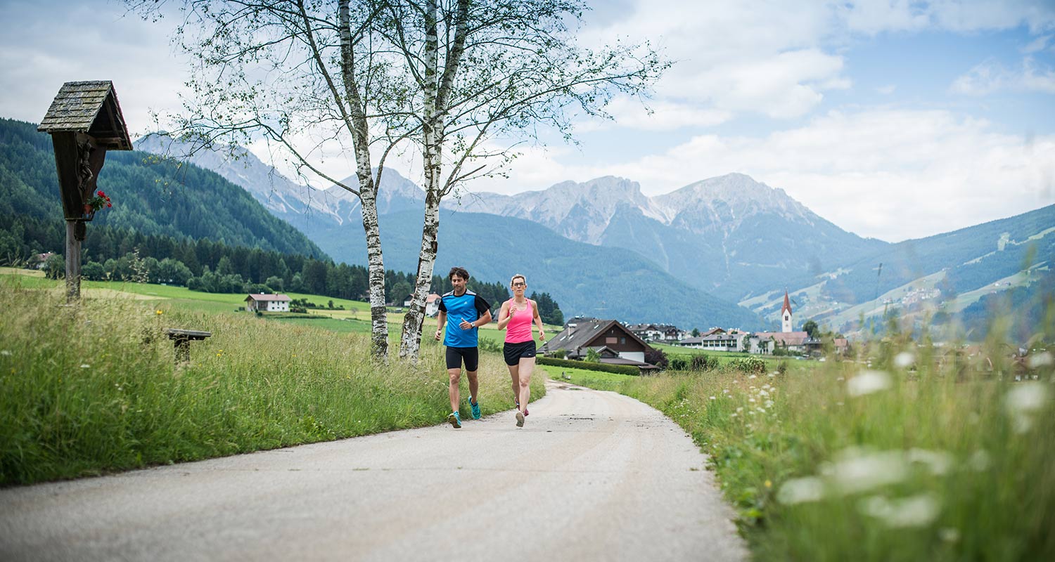 Coppia fa jogging lungo una strada di campagna in estate