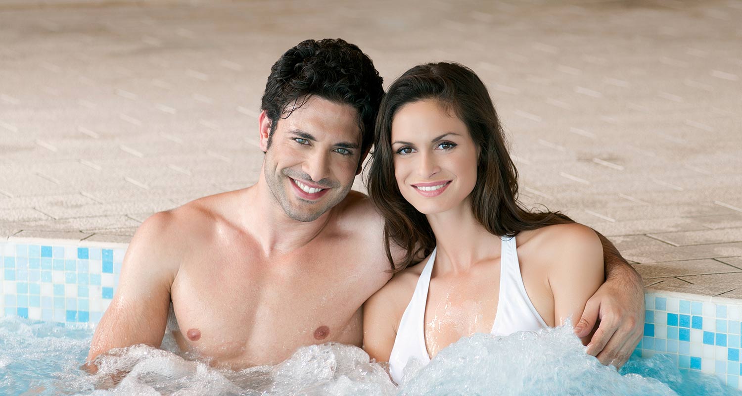 Smiling couple in the whirlpool of the wellness area at Sporthotel Rasen